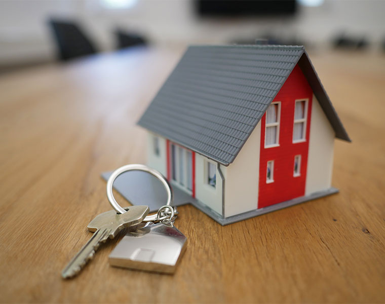 A small model house and a key on a ring